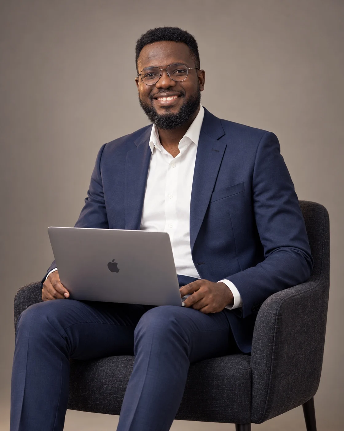 Portrait of Sola Mathew seated with a MacBook